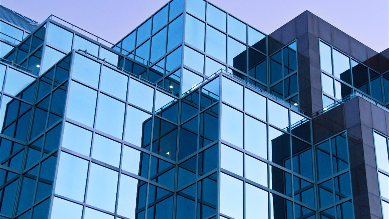 Glass curtain wall of a modern building seen from below