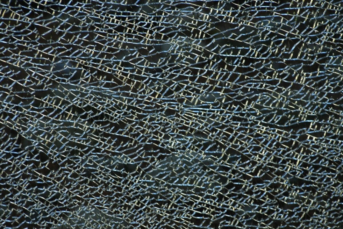 Close-up of shattered toughened glass holding its crazed pattern