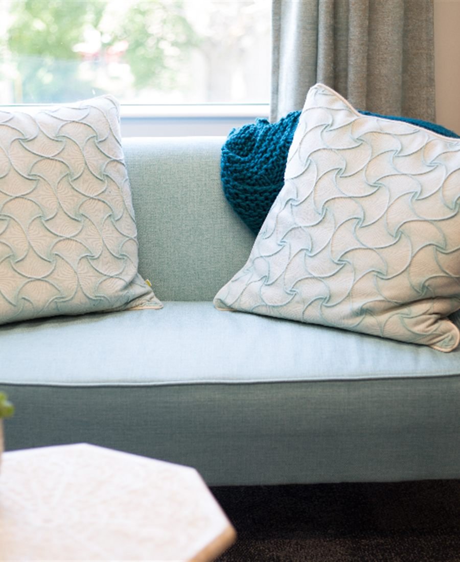 Living room with a pale blue sofa beside a curtained window